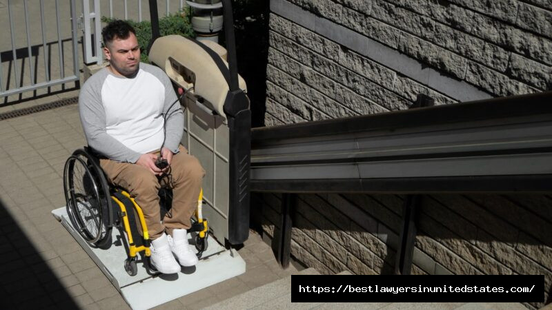 Wheelchair user stopped at an apartment complex staircase with limited accessibility, highlighting potential safety and premises liability concerns in shared residential areas
